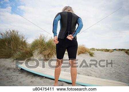 Senior woman putting on wetsuit, rear view View Large Photo Image Stock Image - Senior woman putting on wetsuit, rear view. Fotosearch