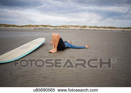Senior woman relaxing on sand, surfboard beside her View Large Photo Image Stock Photography - Senior woman relaxing on sand, surfboard beside her. Fotosearch