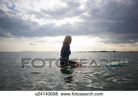 Senior woman sitting on surfboard in sea, rear view View Large Photo Image Stock Photo - Senior woman sitting on surfboard in sea, rear view. Fotosearch