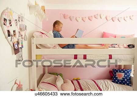 Side view of girl sitting on top bunk of bunkbed reading magazine View Large Photo Image Stock Image - Side view of girl sitting on top bunk of bunkbed reading magazine. Fotosearch
