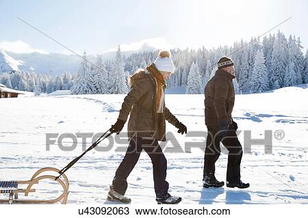 Side view of senior couple on snowy landscape pulling sledge, Sattelbergalm, Tyrol, Austria View Large Photo Image Stock Image - Side view of senior couple on snowy landscape pulling sledge, Sattelbergalm, Tyrol, Austria. Fotosearch