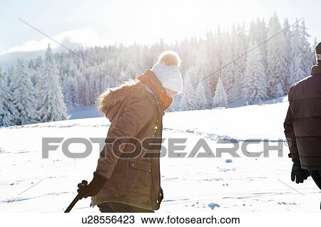 Stock Image - Side view of senior woman on snowy landscape, Sattelbergalm, Tyrol, Austria. Fotosearch
