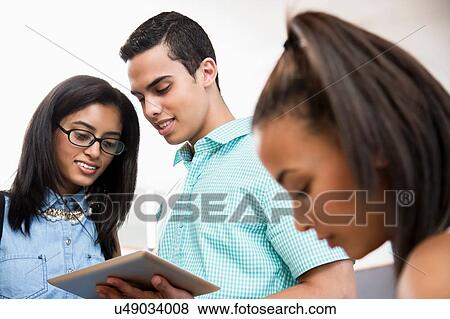 Students in classroom, looking at digital tablet View Large Photo Image Stock Photo - Students in classroom, looking at digital tablet. Fotosearch