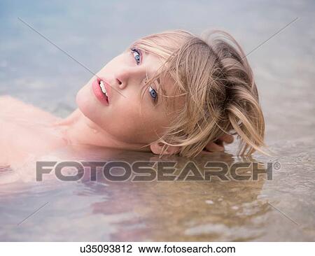 Sultry bare shouldered young woman lying in shallow lake View Large Photo Image Stock Image - Sultry bare shouldered young woman lying in shallow lake. Fotosearch