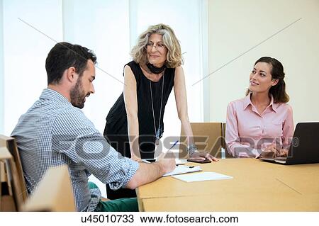 Three designers brainstorming at boardroom table View Large Photo Image Stock Image - Three designers brainstorming at boardroom table. Fotosearch