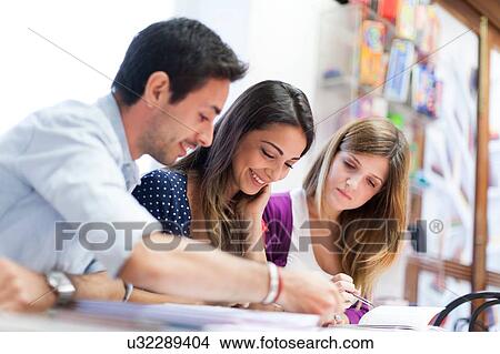 Three friends sitting together, studying View Large Photo Image Picture - Three friends sitting together, studying. Fotosearch