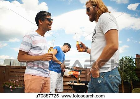 Three male friends drinking beer at rooftop barbecue View Large Photo Image Stock Photography - Three male friends drinking beer at rooftop barbecue. Fotosearch