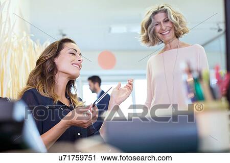 Two businesswomen talking in office View Large Photo Image Stock Image - Two businesswomen talking in office. Fotosearch