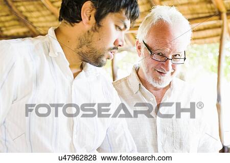 Two men talking at safari lodge, Kafue National Park, Zambia View Large Photo Image Stock Photo - Two men talking at safari lodge, Kafue National Park, Zambia. Fotosearch