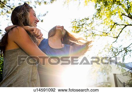 Two teenage girls dancing in sunlit park View Large Photo Image Stock Image - Two teenage girls dancing in sunlit park. Fotosearch