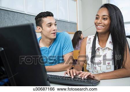 Stock Photograph - Two teenagers typing in high school computer class. Fotosearch