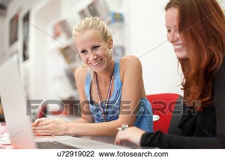 Two women, studying together View Large Photo Image Stock Image - Two women, studying together. Fotosearch