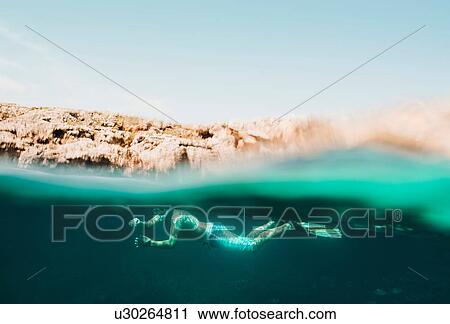 Stock Image - Underwater surface view of mature man sea snorkeling, Menorca, Balearic islands, Spain. Fotosearch