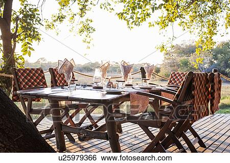 Stock Photograph - View of dining table at safari lodge, Kafue National Park, Zambia. Fotosearch