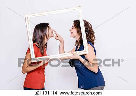 Picture - View through picture frame of lesbian couple face to face. Fotosearch