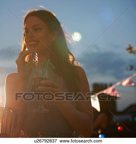 Stock Photo - Woman at early evening party. Fotosearch