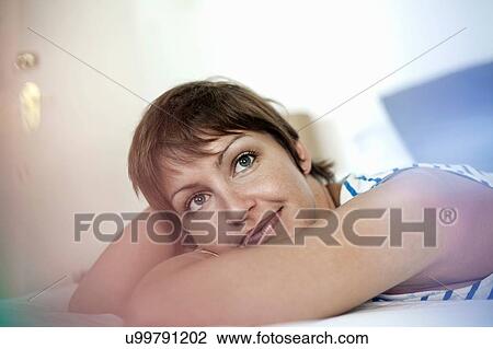 Stock Image - Woman daydreaming in bed. Fotosearch