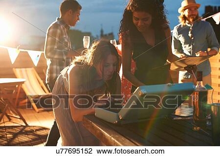 Woman putting on music at early evening party View Large Photo Image Stock Image - Woman putting on music at early evening party. Fotosearch