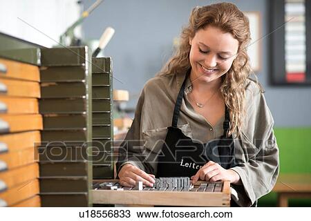 Stock Image - Woman with letterpress tray in printing workshop. Fotosearch