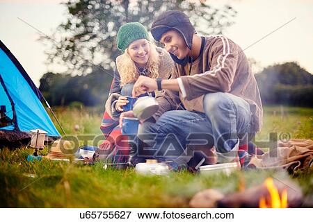 Young camping couple pouring tea View Large Photo Image Stock Photo - Young camping couple pouring tea. Fotosearch