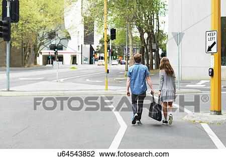 Stock Image - Young couple carrying bag together on street, Melbourne, Victoria, Australia. Fotosearch