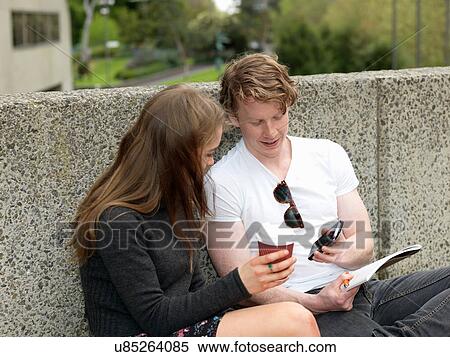 Young couple having coffee, using smartphone, against concrete wall, Melbourne, Victoria, Australia View Large Photo Image Stock Photography - Young couple having coffee, using smartphone, against concrete wall, Melbourne, Victoria, Australia. Fotosearch