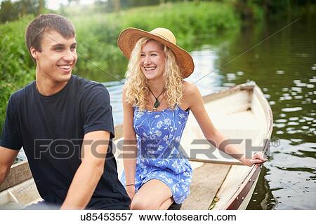 Young couple in rowing boat on rural river View Large Photo Image Stock Photo - Young couple in rowing boat on rural river. Fotosearch