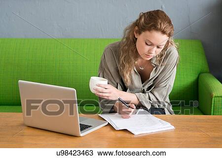 Young female designer making notes from office sofa View Large Photo Image Stock Image - Young female designer making notes from office sofa. Fotosearch