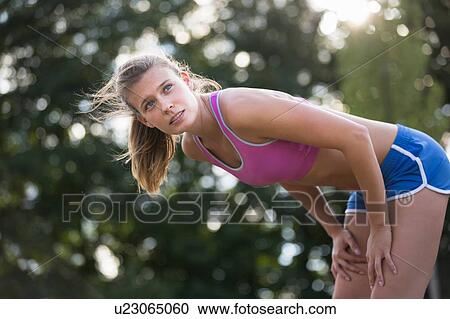 Young female runner bending forward taking a break View Large Photo Image Stock Image - Young female runner bending forward taking a break. Fotosearch