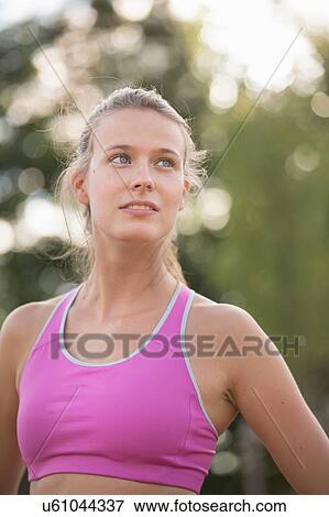 Young female runner looking over her shoulder View Large Photo Image Stock Photo - Young female runner looking over her shoulder. Fotosearch