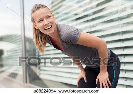 Young female runner taking a break in city View Large Photo Image Picture - Young female runner taking a break in city. Fotosearch