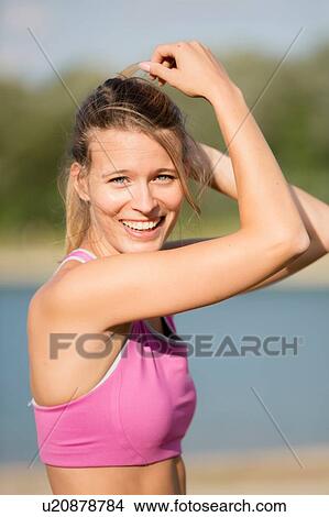 Young female runner with hand in hair at lakeside View Large Photo Image Picture - Young female runner with hand in hair at lakeside. Fotosearch