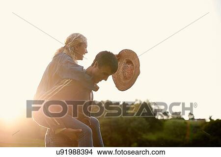 Young man giving girlfriend a piggyback View Large Photo Image Picture - Young man giving girlfriend a piggyback. Fotosearch