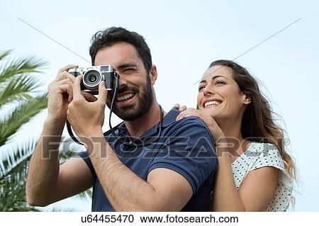 Young man with girlfriend taking photographs View Large Photo Image Stock Image - Young man with girlfriend taking photographs. Fotosearch