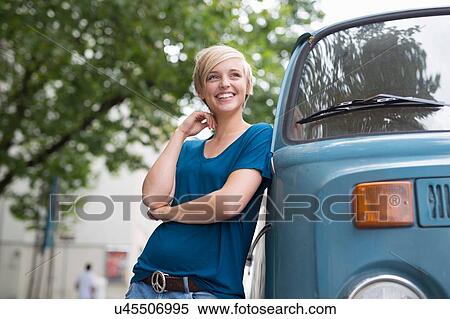 Young woman leaning against parked campervan View Large Photo Image Stock Photography - Young woman leaning against parked campervan. Fotosearch