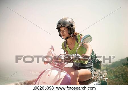 Young woman riding moped View Large Photo Image Stock Photo - Young woman riding moped. Fotosearch