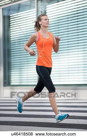 Young woman running in city View Large Photo Image Stock Photo - Young woman running in city. Fotosearch
