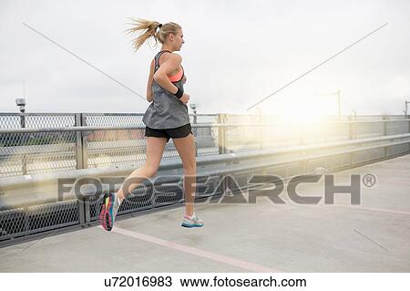 Young woman running, outdoors, rear view View Large Photo Image Stock Image - Young woman running, outdoors, rear view. Fotosearch