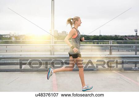 Stock Photo - Young woman running, outdoors. Fotosearch
