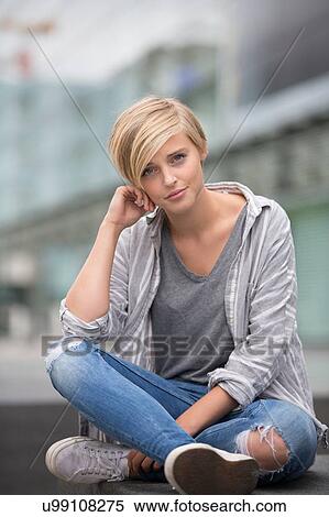 Young woman sitting cross legged in city View Large Photo Image Stock Photography - Young woman sitting cross legged in city. Fotosearch