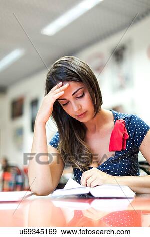 Young woman, sitting, studying View Large Photo Image Stock Photo - Young woman, sitting, studying. Fotosearch