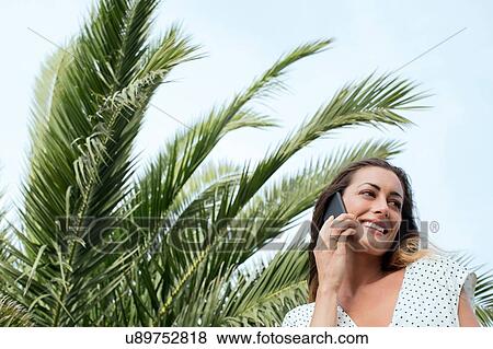 Young woman talking on smartphone View Large Photo Image Stock Photo - Young woman talking on smartphone. Fotosearch