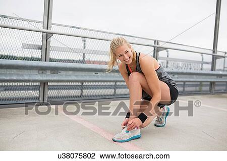 Young woman trying shoes, preparing for workout View Large Photo Image Stock Image - Young woman trying shoes, preparing for workout. Fotosearch