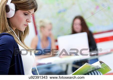 Young woman wearing headphones, studying View Large Photo Image Stock Image - Young woman wearing headphones, studying. Fotosearch