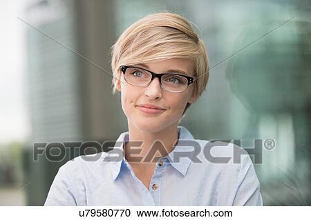 Young woman wearing stylish spectacles in city View Large Photo Image Stock Image - Young woman wearing stylish spectacles in city. Fotosearch