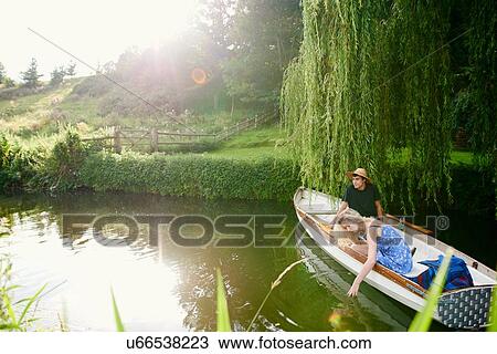 Young woman with boyfriend touching water from river rowing boat View Large Photo Image Stock Image - Young woman with boyfriend touching water from river rowing boat. Fotosearch