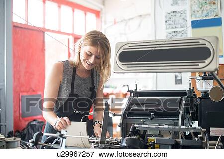 Young woman working with traditional letterpress print machine in workshop View Large Photo Image Stock Photo - Young woman working with traditional letterpress print machine in workshop. Fotosearch