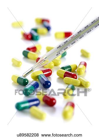 Stock Illustration - Capsules and a thermometer, close up.. Fotosearch
