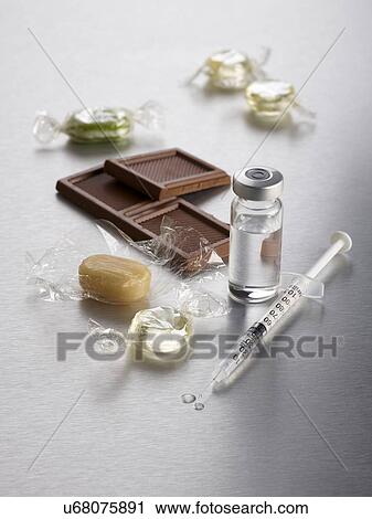 Clip Art - Diabetes, conceptual image. Sweets, chocolate and an insulin injection.. Fotosearch