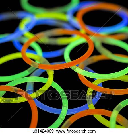 Glowstick bangles against a black background. View Large Illustration Stock Illustration - Glowstick bangles against a black background.. Fotosearch